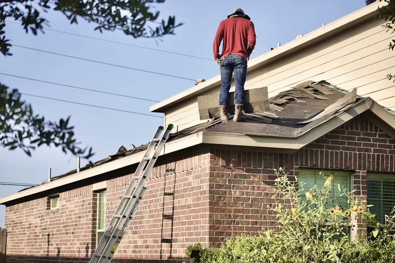 Professional roofer working on a residential roof in Roxanna